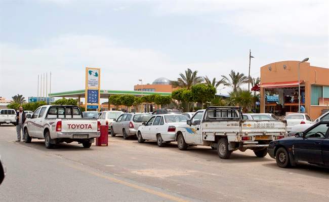 In this photo made during a city tour organized by Libyan government on Thursday, April 21, 2011, motorists wait to fill their cars in Tripoli, Libya. Furtive acts of resistance are the most that those seeking Moammar Gadhafi's ouster have been able to muster under the heavy weight of fear that the regime has imposed to prevent any uprising in the most important stronghold of his rule. At the same time, major disruptions in daily life in the capital _ a result of international sanctions _ are bound to further erode support for the regime. (AP Photo/Darko Bandic).