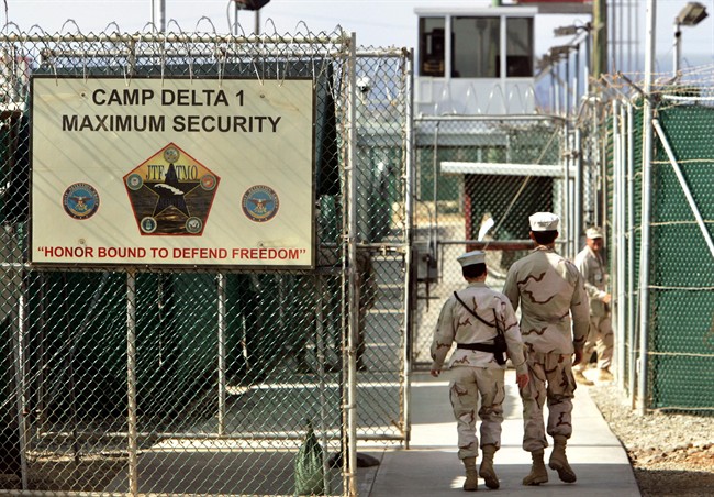 In this June 27, 2006 file photo, reviewed by a US Department of Defense official, U.S. military guards walk within Camp Delta military-run prison, at the Guantanamo Bay U.S. Naval Base, Cuba. 