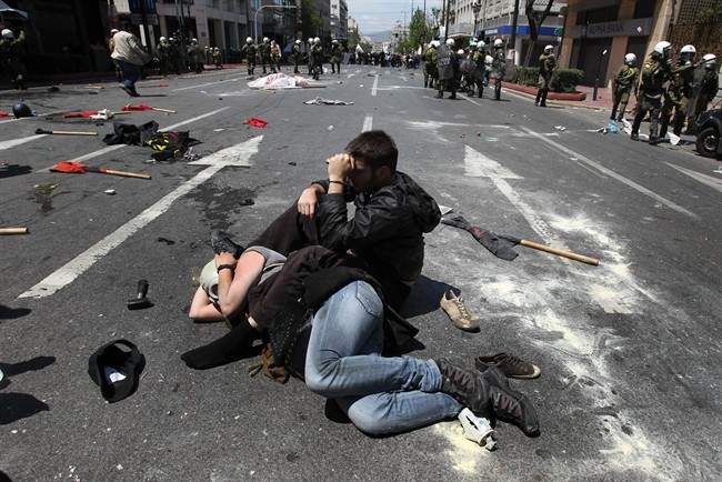 Protesters lay on the street after clashes with riot police during a 24-hour strike in Athens, Wednesday, May 11, 2011. Riot police made heavy use of tear gas and stun grenades to disperse youths throwing stones and petrol bombs during a march attended by 20,000 people to protest the Greek government's harsh austerity measures.(AP Photo/ Petros Giannakouris).