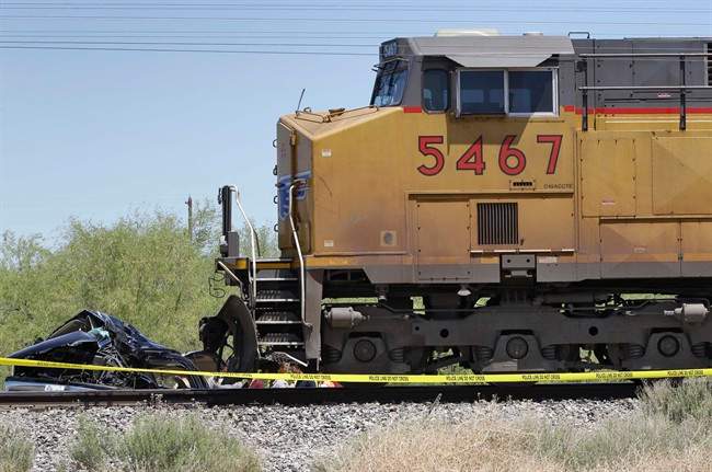 The wreckage of a Border Patrol SUV sits on the tracks in front of a freight train Thursday, May 12, 2011 in Gila Bend, Ariz. hours after their collision in the early morning hours. Authorities say a fast-moving freight train that collided with an SUV, killing two Border Patrol agents, tried to get the driver's attention by blowing its horn before the crash. (AP Photo/Matt York).