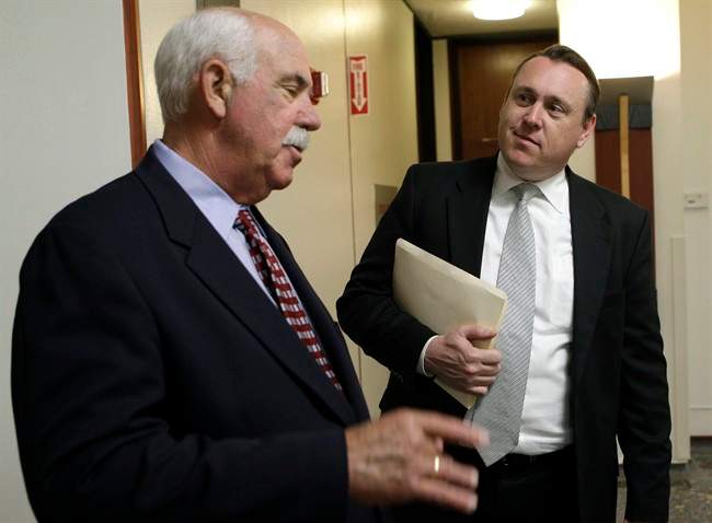 Evergreen Cemetery director Ronald Haulman, right, listens as his attorney Steven Gurnee speaks to reporters at Alameda County Superior Court in Oakland, Calif., Thursday, May 12, 2011. A woman who lost 27 relatives in the 1978 Jonestown tragedy is waging a legal battle against a California cemetery over a memorial to the 918 victims that includes the name of Peoples Temple leader Jim Jones. The Rev. Jynona Norwood appeared Thursday in court in an attempt to block further construction and use of the memorial at Evergreen Cemetery in Oakland. (AP Photo/Jeff Chiu).