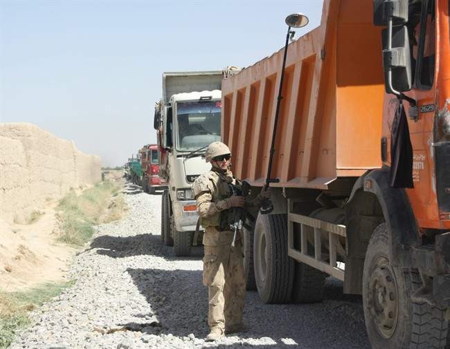 A Canadian soldier checks a gravel-delivery truck at the end of Route Hyena, a 15-kilometre Canadian-built road that runs the length of western Panjwaii district in southern Afghanistan, on Sunday, April 17, 2011. The road may be one of Canada’s most enduring successes. THE CANADIAN PRESS/Colin Perkel.