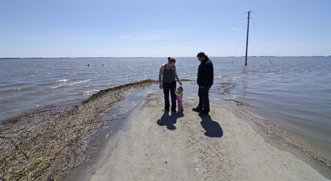 Reba Corrigan and Andy Krahn took their one-year-old daughter Page out to see the flood waters in Morris, Manitoba on Monday April 25, 2011 as the Red River and the Morris River remain at high levels. THE CANADIAN PRESS/David Lipnowski.