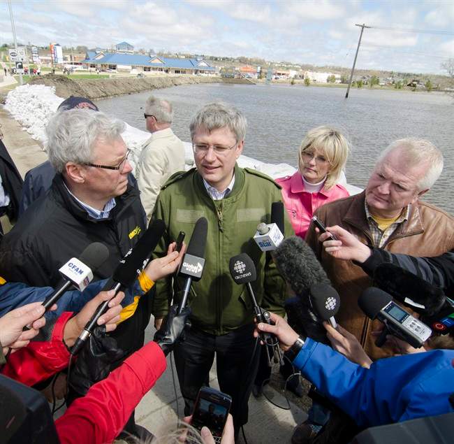 Manitoba Premier Greg Selinger (left to right), Prime Minister Stephen Harper, Brandon Mayor Shari Decter Hirst, and Conservative MP for Brandon Souris Mirv Tweed speak to the media along the dikes holding back the Assiniboine Rive along the 18th Street Bridge in Brandon Manitoba Wednesday May 11, 2011. THE CANADIAN PRESS/David Lipnowski.