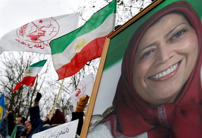 FILE - A Thursday Dec. 31, 2009 photo from files showing protestors at a rally alongside a poster of Maryam Rajavi, head of the National Council of Resistance of Iran outside the Iranian embassy in London. French investigators have dropped terror charges against 24 members of an exiled Iranian opposition group whose arrest in 2003 triggered several sympathizers to set themselves alight in protest. Judicial officials said Thursday, May 12, 2011, that nine people remained under investigation for financial misdoings, including suspicion of financing terrorist groups. The officials were not authorized to speak publicly and asked not to be named. (AP Photo/Kirsty Wigglesworth, File).