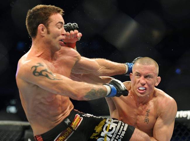 Fighters Georges St-Pierre, right, battles against Jake Shields during the welter weight championship match at UFC 129 in Toronto on Saturday, April 30, 2011. St-Pierre defeated Shields in a five-round decision to defend his welterweight title. THE CANADIAN PRESS/Nathan Denette.