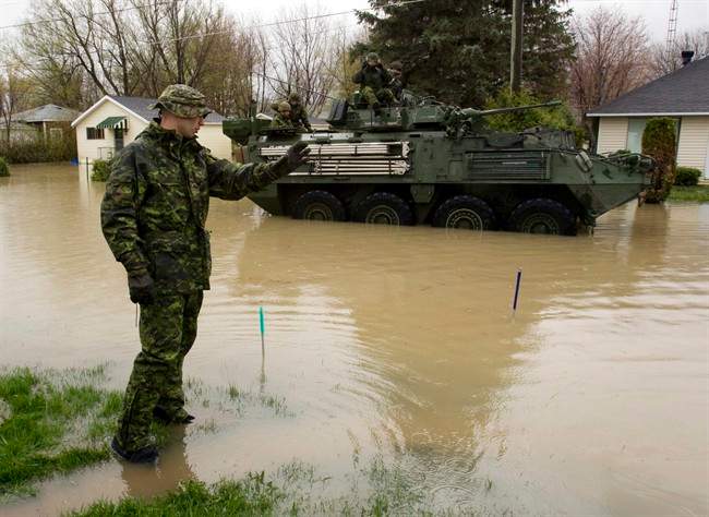 Soldiers from the 22nd Regiment, known as the VanDoos, drive their light armoured vehicle through the flooded streets of Saint Blaise, Que., Thursday, May 5, 2011. THE CANADIAN PRESS/Ryan Remiorz.