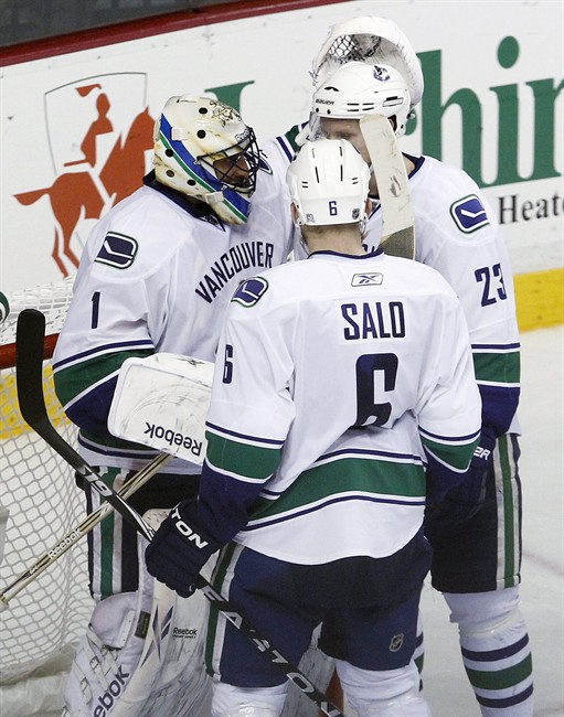 Vancouver Canucks goalie Roberto Luongo (1) celebrates with Sami Salo (6), of Finland, and Alexander Edler (23), of Sweden, after the Canucks beat the Nashville Predators in Game 4 of a second-round NHL hockey Stanley Cup playoff series, Thursday, May 5, 2011, in Nashville, Tenn. The Canucks won 4-2 to take a 3-1 lead in the series. (AP Photo/Mark Humphrey).