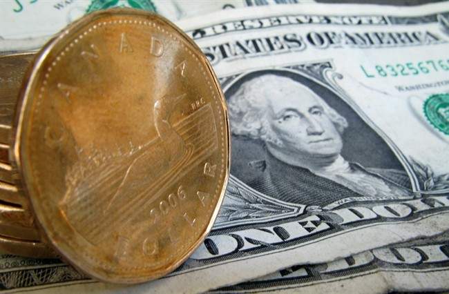 Canadian dollars, or loonies, sits on their American counterparts on Sept. 20, 2007 in Montreal.