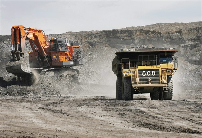 A haul truck carryong a full load drives away from a mining shovel at the Shell Albian Sands oilsands mine near Fort McMurray, Alta., Wednesday, July 9, 2008.