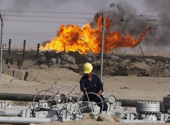 In this Dec. 13, 2009 file photo, an Iraqi worker operates valves at the Rumaila oil refinery, near the city of Basra, 550 kilometers (340 miles) southeast of Baghdad, Iraq. THE CANADIAN PRESS/AP, Nabil al-Jurani.