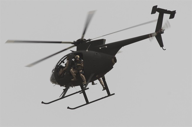 Security contractors are seen in a helicopter in Baghdad, Iraq, after a roadside bomb struck a private security convoy Monday, June 6, 2011. (AP Photo/Khalid Mohammed).