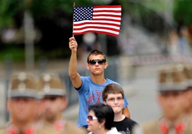 A young man waves a US flag during the unveiling ceremony of the new statue of late US President Ronald Reagan in Budapest, Hungary, Wednesday, June 29, 2011. The new statue honors Reagan to mark his efforts to free the people of Hungary from the yoke of communism. (AP Photo/Bela Szandelszky).