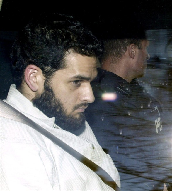 Momin Khawaja, an Ottawa computer software programmer, leaves the Ottawa courthouse Monday May 3, 2004 under RCMP protection. Khawaja, the first person ever charged under Canada’s anti-terror laws finds out Thursday whether the country’s top court will hear his appeal on the legal definition of “terrorist activity.” THE CANADIAN PRESS/Tom Hanson