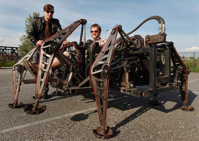 Leigh Christie, left, executive director of the eatArt foundation, and Jonathan Tippett, eatArt member and co-creator of the Mondospider, pose for a photograph with the massive walking machine in Vancouver, B.C., on Tuesday June 22, 2010. A growing community of people are living by the philosophy that if it can be dreamt, it can most certainly be built. Ideas that might be deemed as whimsical, inane or impossible by less ambitious folk, are being nurtured, shared and created by this fast-growing movement. THE CANADIAN PRESS/Darryl Dyck.