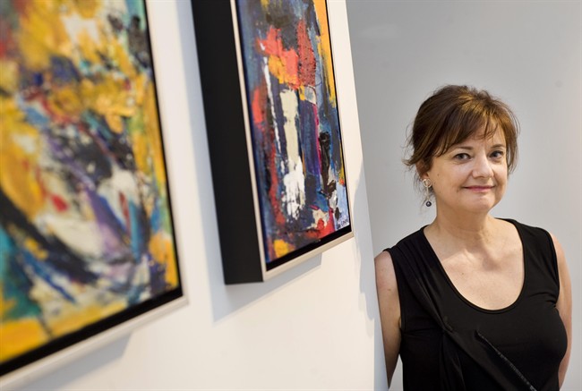 Judge Suzanne Coupal poses for a photograph next to some of her paintings at a gallery in Montreal, Wednesday, June 1, 2011. The CANADIAN PRESS/Graham Hughes.