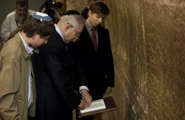 FILE - In this Wednesday, April 1, 2009 file photo, Israeli Prime Minister Benjamin Netanyahu reads from a prayer book as he stands with his sons Yair, right, and Avner at the Western Wall, the holiest site where Jews can pray, in Jerusalem's Old City. An Israeli paper said Friday, June 24, 2011, the Israeli prime minister's son has posted offensive comments about Arabs and Muslims on his Facebook page. The daily Haaretz found that earlier this year 19-year-old Yair Netanyahu posted that Muslims "celebrate hate and death." (AP Photo/Sebastian Scheiner, File).