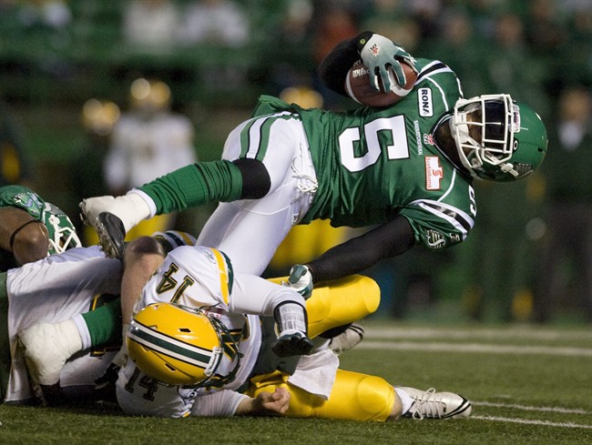 Saskatchewan Roughriders linebacker Byron Bullock, right, carries the ball after a fumble while he is tackled by Edmonton Eskimos quarterback Marc Mueller during the third quarter of CFL football action at Mosaic Stadium on Friday June 17, 2011 in Regina. THE CANADIAN PRESS/Liam Richards.