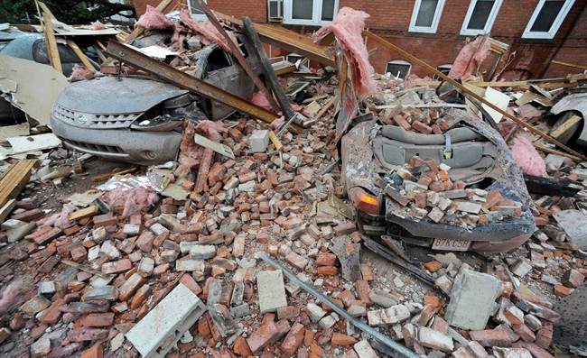 Bricks and debris that fell from a building lay on top of cars after a report of a tornado in Springfield, Mass., Wednesday, June 1, 2011. An apparent tornado struck downtown Springfield, one of Massachusetts' largest cities, scattering debris, toppling trees, and frightening workers and residents. (AP Photo/Jessica Hill).
