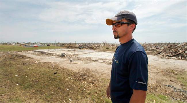 In this May 30, 2011 photo, Scott Vorhees surveys his lot in a devastated Joplin, Mo., neighborhood after clearing tornado debris away. Vorhees has already had a contractor on the site and hopes to begin rebuilding as soon as possible after an EF-5 tornado destroyed his home along with a 6-mile swath through the city killing at least 120 people. (AP Photo/Charlie Riedel).