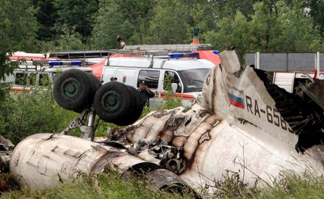 Emergency Ministry cars seen near a wreckage of Tu-134 plane, belonging to the RusAir airline, near the city of Petrozavodsk Tuesday, June 21, 2011.The passenger jet crashed in heavy fog and burst into flames late Monday on a highway in northwestern Russia, just short of a runway whose fog lights had failed, killing 44 people, officials said. Eight people survived the crash.(AP Photo/Timur Khanov, Komsomolskaya Pravda) RUSSIA OUT.