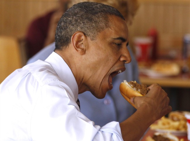 President Barack Obama takes a bite out of a chili dog during an unannounced visit to Rudy's Hot Dog in Toledo, Ohio, Friday, June 3, 2011. (AP Photo/Charles Dharapak).