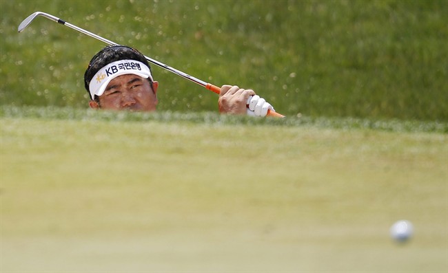 Y. E. Yang, of South Korea, watches his ball roll onto the third green after hitting out of a bunker during the second round of the U.S. Open Championship golf tournament in Bethesda, Md., Friday, June 17, 2011. (AP Photo/Eric Gay).