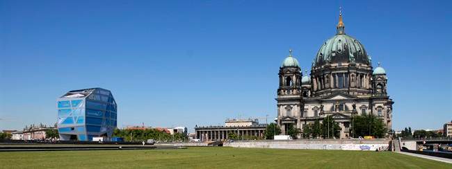 Berlin's newest tourist attraction, the Humboldt Box, left, is pictured on its opening day, Wednesday, June 29, 2011, next to the Berlin Cathedral. The futuristic box will sit for the next few years on a downtown square where a replica Prussian palace is to be built. The Humboldt Box rises some 92 feet (28 meters) above one end of the capital's Unter den Linden boulevard, opposite the neo-classical Museum Island complex. The roughly hexagonal silver-and-blue building offers spectacular views and hosts exhibitions on the planned palace, construction of which has been delayed as part of an austerity package. (AP Photo/Shane Thomas McMillan).