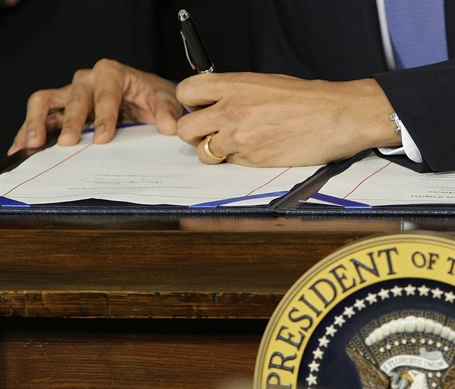 FILE - In this March 23, 2010, file photo President Barack Obama signs the health care bill in the East Room of the White House in Washington. Presidents of both parties have been using autopens decades. But in May, 2011, Obama while overseas directed his Washington staff to use it to sign a bill into law, apparently a first. Stephen Koschal, an autograph authenticator who two years ago published a guide to presidential autopen signatures said "I'd pay peanuts for it." "It's not a real signature," he said. (AP Photo/J. Scott Applewhite, File).
