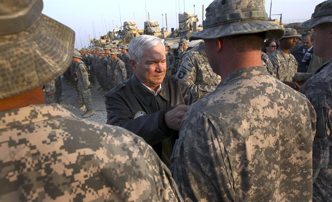 In this photo taken Dec. 7, 2010, Defense Secretary Robert Gates pins Combat Infantry badges on soldiers at Forward Operating Base Connolly in Kunar Province, Afghanistan. Before becoming Defense Secretary Gates realized his heaviest burden would be the inescapable worry about the thousands of young American men and women he would send to fight and die on foreign battlefields. In a chance encounter a military mom said to him, " 'I have two sons in Iraq. For God's sake, bring them home safe. And we'll be praying for you.' Now that's real pressure," he told the Senate committee considering his nomination. (AP Photo/Win McNamee, Pool).