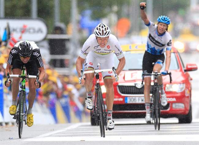 Teammate Ryder Hesjedal of Canada, right, clenches his fist as teammate Thor Hushovd of Norway, center, crosses the finish line to win the 16th stage of the Tour de France cycling race over 162.5 kilometers (101 miles) starting in Saint Paul Trois Chateaux and finishing in Gap, southern France, Tuesday July 19, 2011. Left is Edvald Boasson Hagen of Norway who took second place. (AP Photo/Laurent Rebours).