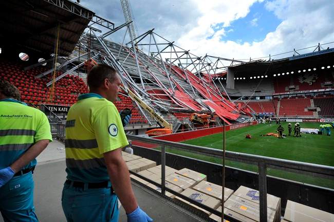 Ambulance workers are seen inside the Grolsch Veste stadium in Enschede, Netherlands, Thursday, July 7, 2011. A section of a Dutch football stadium collapsed during off-season construction work in trapping people underneath, police said. The mayor of Enschede says at a press conference one worker was killed and 10 hospitalized. (AP Photo/Tubantia/Carlo ter Ellen) NETHERLANDS OUT, EDITORIAL USE ONLY, NO SALES, MANDATORY CREDIT.