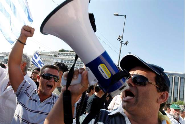 Protesting taxi drivers chant slogans during a demonstration outside the Greek Parliament in central Athens on Tuesday, July 26, 2011. Striking taxi drivers from across Greece gathered in Athens Tuesday to protest new licensing rules as part of the government's austerity measures. (AP Photo/Petros Giannakouris).