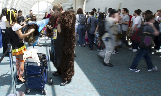 Jed Williston checks his cellphone as he takes a break from being Bigfoot at Comic Con Saturday, July 23, 2011, in San Diego. (AP Photo/Gregory Bull).