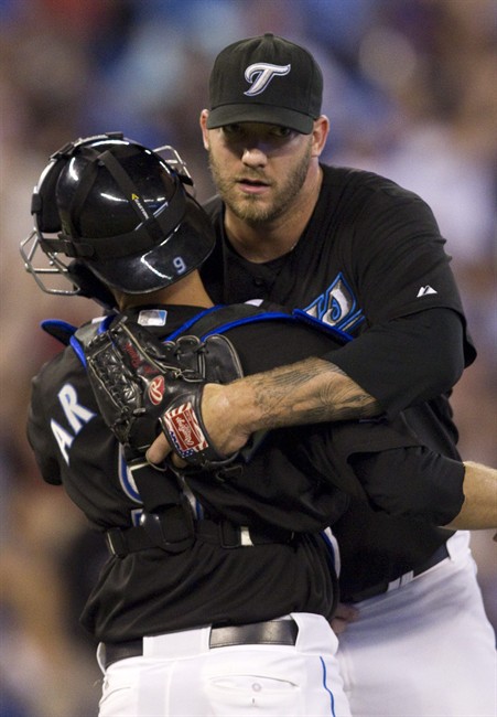 Toronto Blue Jays catcher J.P Arencibia (left) is hugged by closing pitcher Jon Rauch after beating Texas Rangers 3-2 in MLB baseball action in Toronto on Friday July 29, 2011. Arencibia hit a game winning three run homer in the fifth inning. THE CANADIAN PRESS/Chris Young.