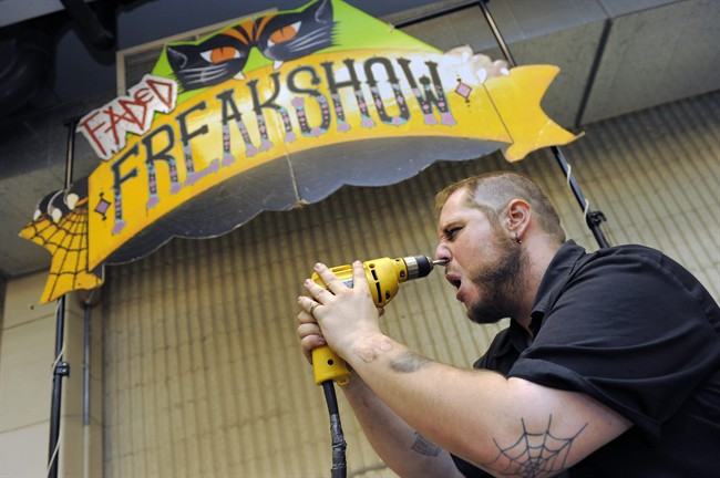 Aaron Woody, 29, of Fort Collins, drills a masonry bit into his face at the freak show at the first Denver County Fair in Denver on Thursday, July 28, 2011. (AP Photo/Chris Schneider).