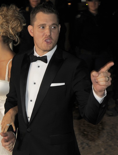 Canadian pop star Michael Buble gestures to fans and photographers as he stands with Argentine TV actress Luisana Lopilato after their wedding in Marcos Paz, Buenos Aires, Argentina, Saturday April 2, 2011. In a live video chat with fans this week, Buble revealed that he's been recording a Christmas album and he's already done a splashy duet with Shania Twain, his fellow Canuck pop star. THE CANADIAN PRESS/AP-Jorge Araujo.