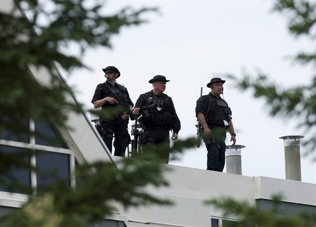 Security personnel keep watch from the roof of the Deerhurst resort as Canadian Prime Minister Stephen Harper greets the G-8 leaders to the G8 Summit in Huntsville, Ont., on Friday June 25, 2010. An internal RCMP review says the Conservative government's choice of Ontario cottage country as the 2010 G8 Summit venue offered would-be snipers "ideal conditions" to assassinate a world leader.THE CANADIAN PRESS/Sean Kilpatrick.