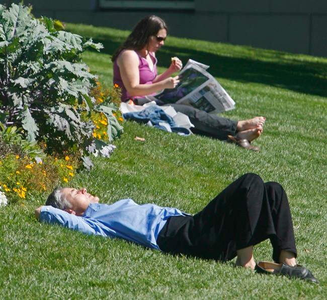 People enjoy the warm sunshine on the Statehouse lawn on the last day of summer in Montpelier, Vt., .