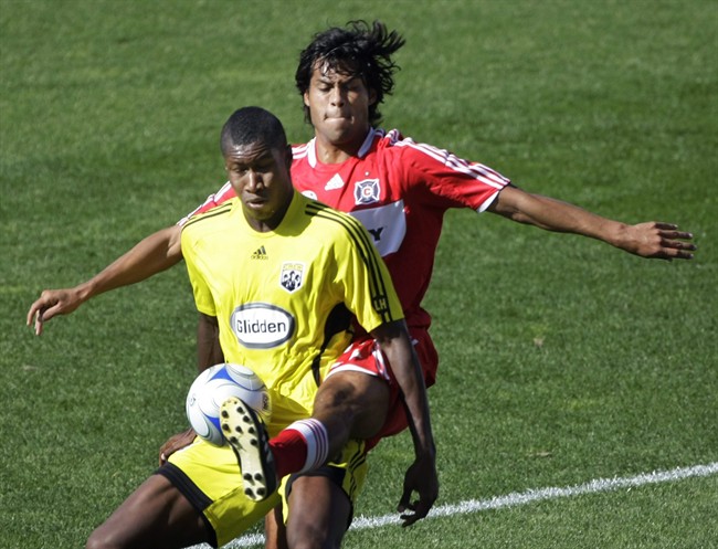 Columbus Crew's Andy Iro, left, has the ball kicked away by Chicago Fire's Wilman Conde, right, during the first half of an MLS soccer match in Bridgeview, Ill., Sunday, Oct. 12, 2008. THE CANADIAN PRESS/AP Photo/Charles Rex Arbogast.