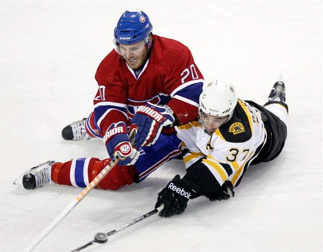 Montreal Canadiens defenseman James Wisniewski (20) and Boston Bruins center Patrice Bergeron (37) dive for a loose puck during second period game three NHL Stanley Cup playoff hockey action Monday, April 18, 2011 in Montreal. The Montreal Canadiens traded the rights to Wisniewski to the Columbus Blue Jackets for a seventh-round pick on Wednesday. THE CANADIAN PRESS/Ryan Remiorz.