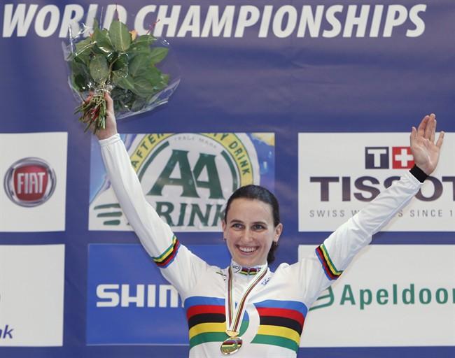 New world champion Tara Whitten of Canada celebrates on the podium of the women's omnium event during the Track Cycling World Championships in Apeldoorn, central Netherlands, March 27, 2011. Whitten will make her Olympic debut after originally dreaming of representing Canada at the Games in cross-country skiing. THE CANADIAN PRESS/ AP - Peter Dejong.