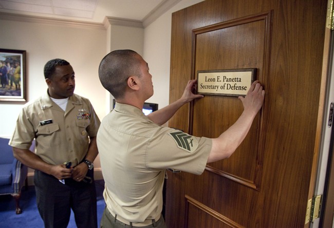 Marine Sgt. John Kang attaches the name plate of incoming Defense Secretary Leon Panetta to his office door at the Pentagon, Friday, July 1, 2011. (AP Photo/Evan Vucci).