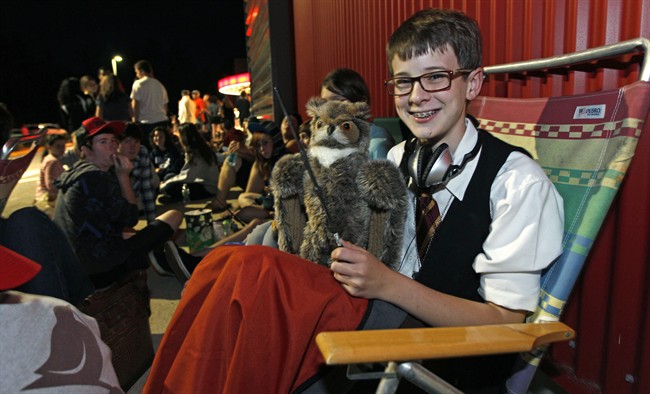 Dressed as Harry Potter, Aidan O'Shea of Hollis, N.H. waits in a line of hundreds of moviegoers for the midnight showing of "Harry Potter and the Deathly Hallows :Part II" in Merrimack, N.H., Thursday, July 14, 2011. (AP Photo/Charles Krupa).