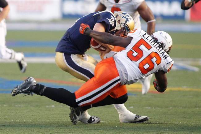 Winnipeg Blue Bombers' Buck Pierce (4) is hit hard by B.C. Lions' Solomon Elimimian (56) in second half CFL action in Winnipeg, Thursday, July 28, 2011. Pierce was pulled from the game after this set of plays and replaced by Alex Brink (7). Winnipeg defeated B.C. 25-20. THE CANADIAN PRESS/John Woods.