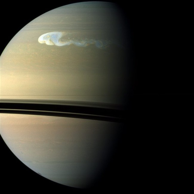 This image provided by NASA shows a Saturn image taken on Dec. 24, 2010 by the Cassini camera showing a storm, upper center, covering an area similar to that from London to Cape Town.(AP Photo/NASA).