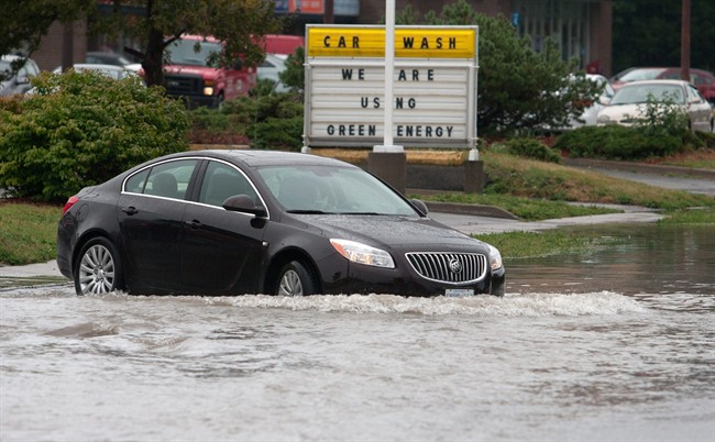 A car leaves a car wash after some severe flooding in Kingston, Ontario on Friday July 29, 2011. Several stores in the downtown area lost power and Kingston Police had to close several roads in the area. THE CANADIAN PRESS/ Lars Hagberg.