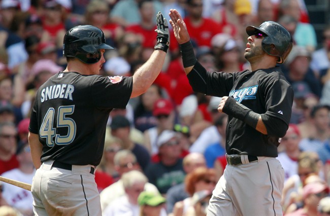 Toronto Blue Jays' Jose Bautista, right, celebrates with teammate Travis Snider (45) after scoring on an RBI single by Aaron Hill in the third inning of a baseball game against the Boston Red Sox in Boston, Monday, July 4, 2011. (AP Photo/Michael Dwyer).