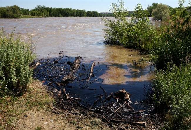 Oil swirls in a flooded gravel pit in Lockwood, Mont. after a pipeline break early Saturday, July 2, 2011.