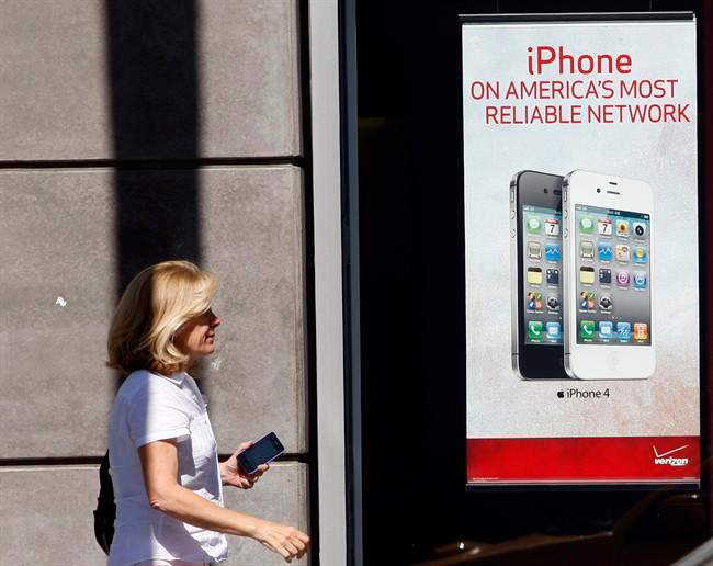 In this July 10, 2011 photo, a woman walks past a Verizon stone in Hollywood. Verizon Communications Inc. is seeing a big boost from the iPhone, adding more new subscribers on contracts in the second quarter than it has in two and half years.(AP Photo/Nick Ut).